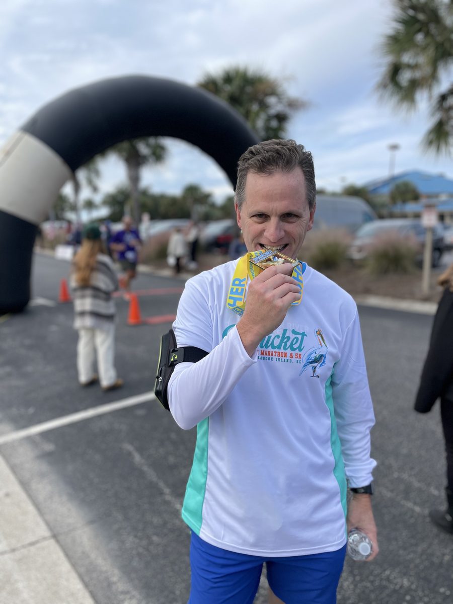 Jimmy biting a finisher's medal at a race